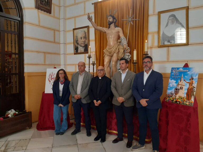 Cinco personas posan ante una imagen del Cristo Resucitado y un cartel conmemorativo.