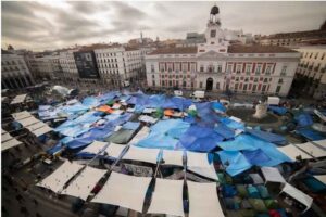 Vista aérea de un mercado con carpas de colores en una plaza urbana