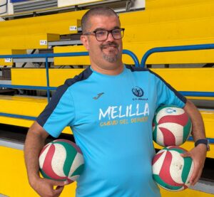 Entrenador Salim Abdelkader sosteniendo pelotas de voleibol en el pabellón