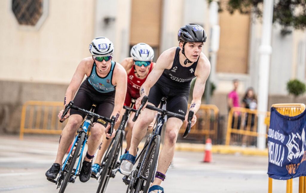 Tres triatletas pedalean en bicicletas durante el segmento ciclista de una competición
