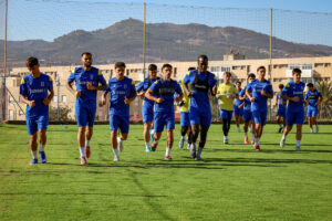 Jugadores de la U.D. Melilla entrenando en el campo con montañas al fondo