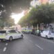 Dos vehículos de la Policía Local estacionados en una calle urbana arbolada.